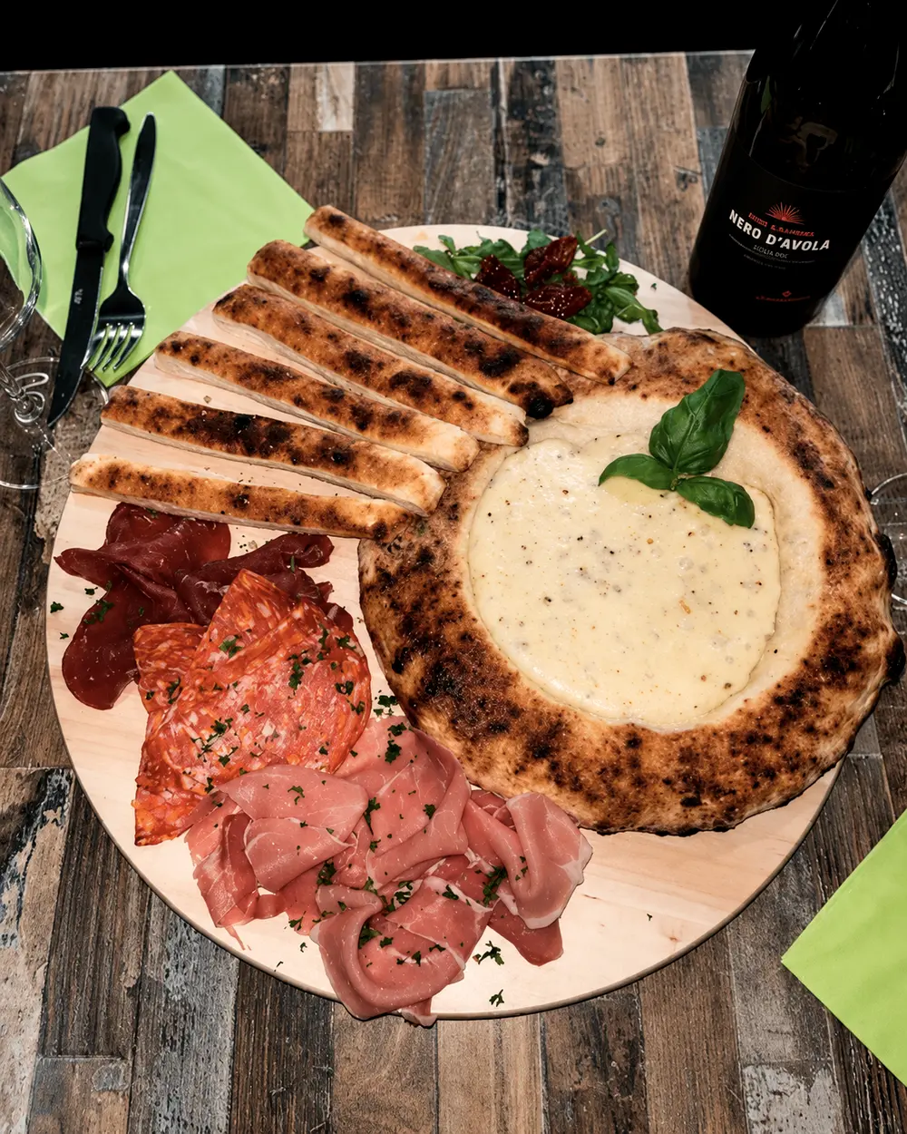 La focaccia savoyarde de la Pizzeria Bambino, fromage à raclette fondu et grissini, à partager.