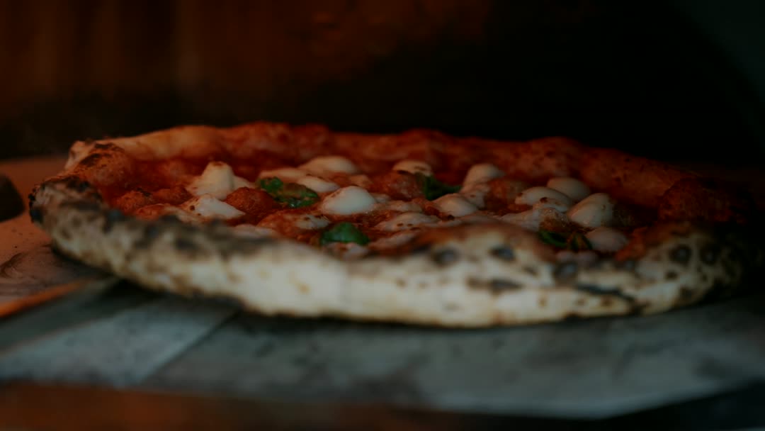 Le feu vivant dans le four à bois de la Pizzeria Bambino.